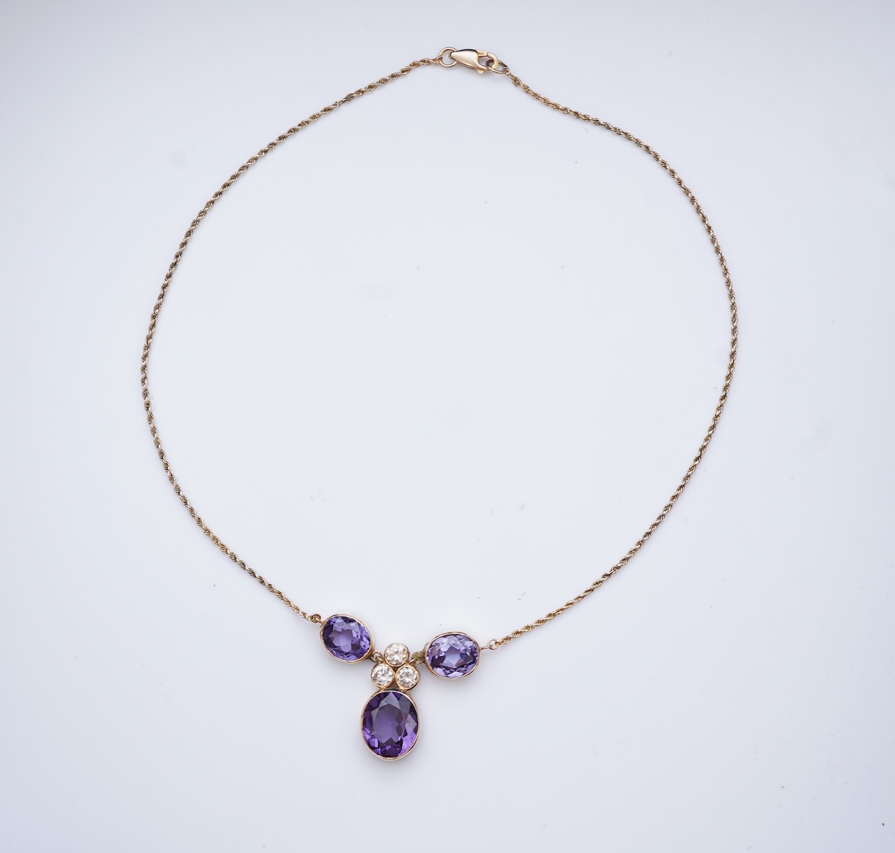 A synthetic colour-change sapphire and diamond pendant necklace
